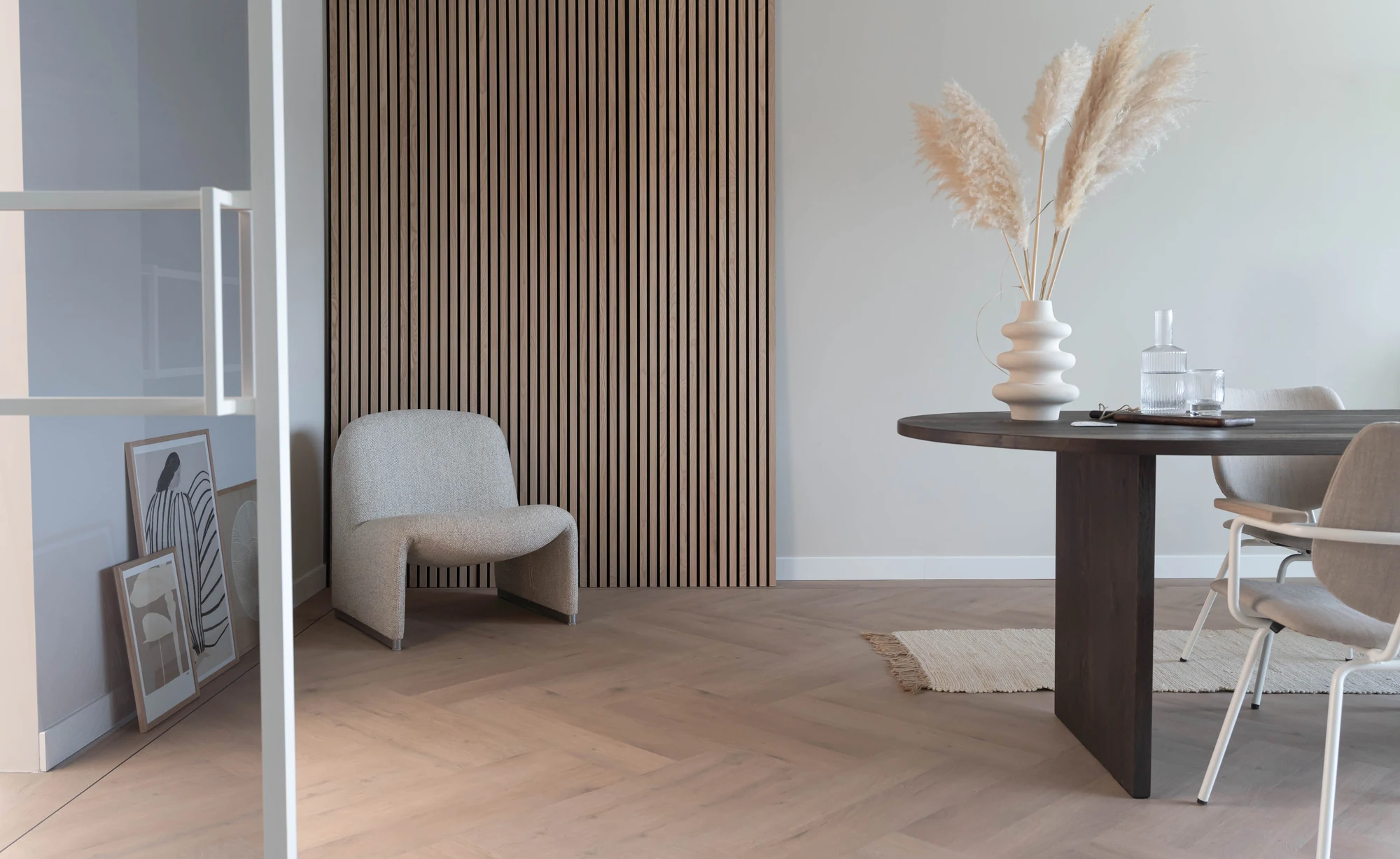 Licht interieur met een warme visgraatvloer, een houten wand en een eettafel
